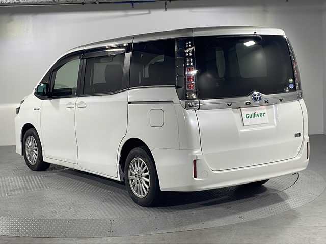 トヨタ ヴォクシー ハイブリッド V 沖縄県 2016(平28)年 9.1万km ホワイトパールクリスタルシャイン 【県外仕入れ】/・純正SDナビ/・フリップダウンモニター/・CD/DVD/BT/フルセグ/・バックカメラ/・ETC/・プリクラッシュセーフティ/・レーンキープアシスト/・クルーズコントロール/・コーナーセンサー/・横滑り防止装置/・オートマチックハイビーム/・アイドリングストップ/・左側パワースライドドア/・D+N席シートヒーター/・classioシートカバー/・LEDヘッドライト/・オートライト/・フォグランプ/・純正15インチAW/・純正フロアマット/・プッシュスタート/・スマートキー
