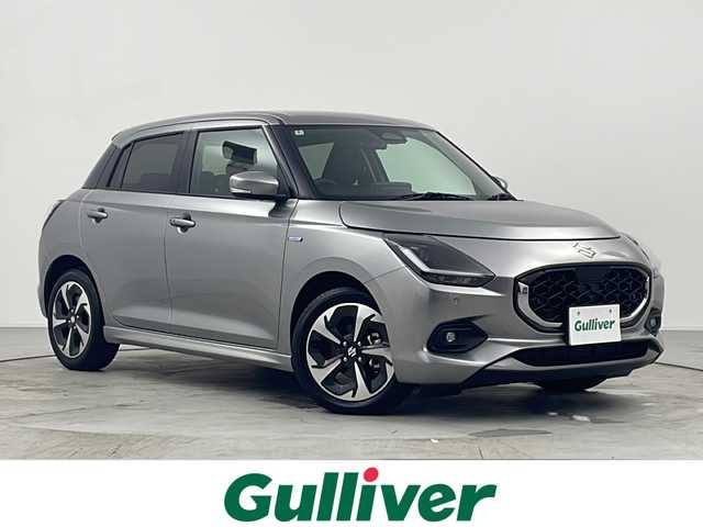 スズキ スイフト HYBRID MZ 愛知県 2024(令6)年 0.3万km プレミアムシルバーメタリック 禁煙車/純正ディスプレイオーディオ/(AM/FM/BT/USB/ipod/スマートフォンリンク)/クルーズコントロール/パドルシフト/シートヒーター/デュアルブレーキサポートII/コーナーセンサー/アイドリングストップ/レーンキープアシスト/横滑り防止装置/BSM/LEDヘッドライト/フロントフォグランプ/オートライト/シートヒーター/電動パーキング/オートブレーキサポート/純正フロアマット/ISOFIX/トノカバー/オートリトラウィンカーミラー/プッシュスタート/スマートキー/スペアキー