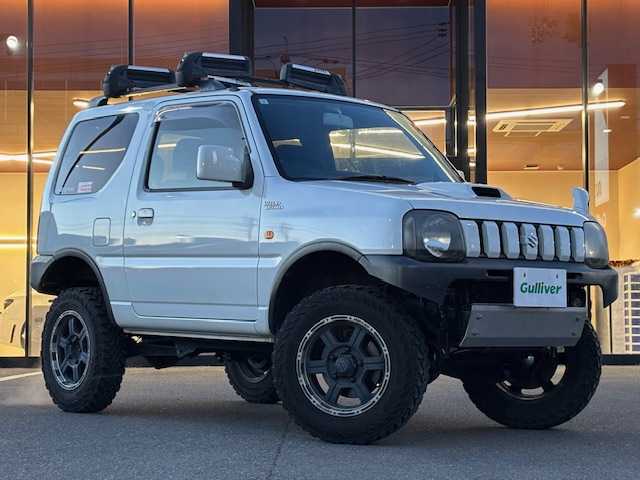 スズキ ジムニー ワイルドウィンド 宮城県 2007(平19)年 15.1万km パールホワイト 登録時走行距離150247km/パワーステアリング/パワーウインド/スペアキー有り/ACエアコン/Bluetooth接続/TV/AM/FM/SD/AUX/HIDヘッドライト/４WD/オフロードマッドタイヤ(ヨコハマ　ジオランダーG003)22年製/ヘッドライトレベライザー/純正フロアマット/純正アルミホイール/ABS/車高調リフトアップ/ルーフレールキャリア付き