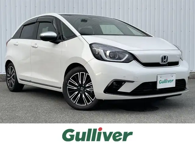 ホンダ フィット e:HEVリュクス 福岡県 2021(令3)年 1.5万km プラチナホワイトパール ホンダセンシング　/社外ナビ　/フルセグＴＶ　/Ｂｌｕｅｔｏｏｔｈ　/オートライト　/ＬＥＤライト／フォグランプ　/前席シートヒーター　/パーキングセンサー　/レザーシート　/革巻きステアリング　/ＡＣＣ　/車線逸脱防止/電動パーキング/ブレーキホールド/ビルドインETC/スマートキー/プッシュスタート/純正アルミホイール/ドアバイザー/ドライブレコーダー