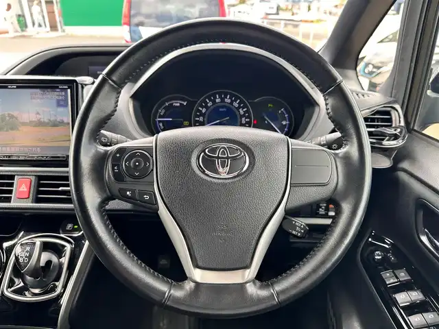 トヨタ ヴォクシー ハイブリッド ZS 煌Ⅱ 宮城県 2019(平31)年 13.6万km イナズマスパーキングブラックガラスフレーク TRDエアロ（F/S/R）/セーフティセンス/・プリクラッシュセーフティ/・レーンディパーチャーアラート/・オートマチックハイビーム/・先行車発進お知らせ機能/インテリジェントクリアランスソナー/パーキングサポートブレーキ/社外10.2インチフリップダウンモニター（TMX-R3300）/社外9インチナビ（AVN-ZX03i）/・CD/DVD/・Bluetooth/・フルセグTV/バックカメラ/ETC/両側パワースライドドア/シートヒーター/革巻きステアリング/クルーズコントロール/ステアリングスイッチ/LEDヘッドランプ/フォグランプ/オートライト/スマートキー＆プッシュスタート/電動格納ミラー/純正16インチAW/純正ドアバイザー/フロアマット/Wエアバッグ