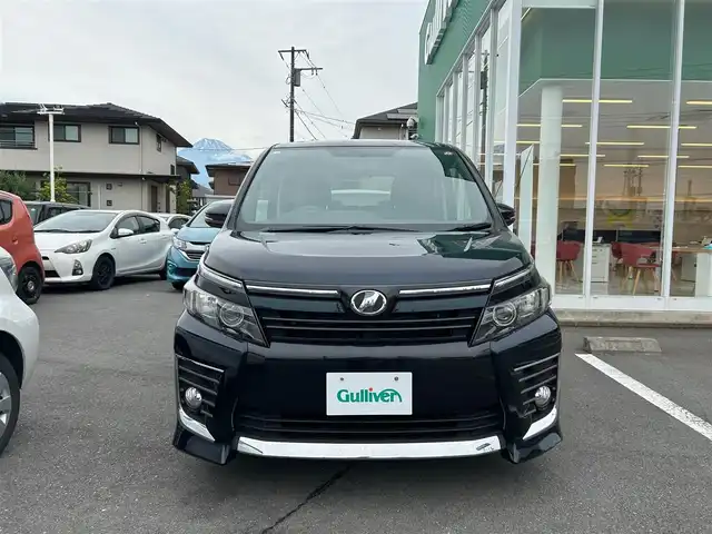 トヨタ ヴォクシー ZS 静岡県 2014(平26)年 4.8万km ブラッキッシュアゲハガラスフレーク エンジンスタートボタン/パワーステアリング/パワーウィンドウ/アイドリングストップ/スマートキー/ダブルオートエアコン/Bluetooth接続/11型後席用モニター/CDチェンジャー/ETC/バックカメラ/SDミュージックサーバー/フルセグTV/純正SDナビ/3列シート/ウォークスルー/純正フロアマット/両側パワースライドドア/純正アルミホイール/ABS/横滑り防止装置/オートライト/LEDヘッドライト/ダブルエアバック