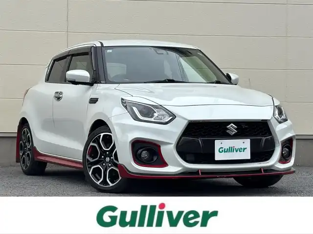 スズキ スイフト スポーツ 茨城県 2019(令1)年 7万km ピュアホワイトP 純正ナビ/(CD/DVD/TV/Bluetooth)/SilkBlazeスポイラー/サブウーファー（ts-wx610a）/スロットルコントローラー（pivot 3-drive pro）/ターボ計（DF19502)/レーダー探知機（AR-W55GA）/社外マフラー（ROSSO MODELLO）/室内LEDライト/xiangshangボンネットダンパー/パドルシフト/全方位カメラ/レーダークルーズコントロール/前後ドライブレコーダー/シートヒーター/レーンキープアシスト/スペアキー/衝突被害軽減ブレーキ/純正17インチアルミホイール