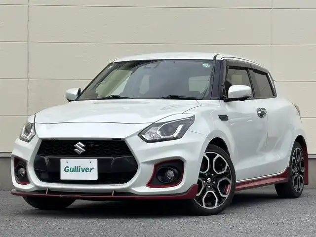 スズキ スイフト スポーツ 茨城県 2019(令1)年 7万km ピュアホワイトP 純正ナビ/(CD/DVD/TV/Bluetooth)/SilkBlazeスポイラー/サブウーファー（ts-wx610a）/スロットルコントローラー（pivot 3-drive pro）/ターボ計（DF19502)/レーダー探知機（AR-W55GA）/社外マフラー（ROSSO MODELLO）/室内LEDライト/xiangshangボンネットダンパー/パドルシフト/全方位カメラ/レーダークルーズコントロール/前後ドライブレコーダー/シートヒーター/レーンキープアシスト/スペアキー/衝突被害軽減ブレーキ/純正17インチアルミホイール