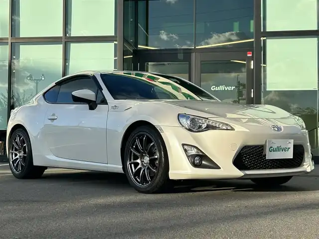 トヨタ ８６ GT 愛媛県 2014(平26)年 1.8万km サテンホワイトパール 社外ナビ（Bluetooth/SD/フルセグテレビ）/前方ドライブレコーダー/ルームミラー型GPSレーダー/ETC2.0/社外18インチAW(ADVAN RACING)/シートカバー/社外エアクリーナー/TRDシフトノブ/TRDマフラー/追加タコメーター(BLITZ)/バックカメラ/純正フロアマット/ABS/横滑り防止装置/オートライト/LEDヘッドライト/フォグランプ/USB入力端子