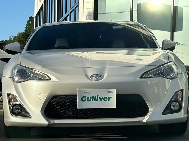 トヨタ ８６ GT 愛媛県 2014(平26)年 1.8万km サテンホワイトパール 社外ナビ（Bluetooth/SD/フルセグテレビ）/前方ドライブレコーダー/ルームミラー型GPSレーダー/ETC2.0/社外18インチAW(ADVAN RACING)/シートカバー/社外エアクリーナー/TRDシフトノブ/TRDマフラー/追加タコメーター(BLITZ)/バックカメラ/純正フロアマット/ABS/横滑り防止装置/オートライト/LEDヘッドライト/フォグランプ/USB入力端子