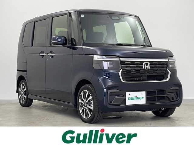 ホンダ Ｎ ＢＯＸ カスタム 大阪府 2024(令6)年 0.1万km ミッドナイトブルービームM 禁煙車/純正9型ナビ/（BT/CD/DVD/AppleCarPlay/AndroidAuto/フルセグ）/片側電動スライドドア/前方ドライブレコーダー/バックカメラ/ETC/ホンダセンシング/・衝突軽減ブレーキ（CMBS）/・誤発進抑制機能（前方・後方）/・歩行者事故低減ステアリング/・路外逸脱抑制機能/・アダプティブクルーズコントロール（ACC）/・車線維持支援システム（LKAS）/・先行車発進お知らせ機能/・標識認識機能/・オートハイビーム/電動パーキング/オートホールド/オートエアコン/USB（Type-A/Type-C）/サンシェード/オートリトラミラー/D/N席シートヒーター/スマートキー/スペアキー/オートライト/LEDヘッドライト