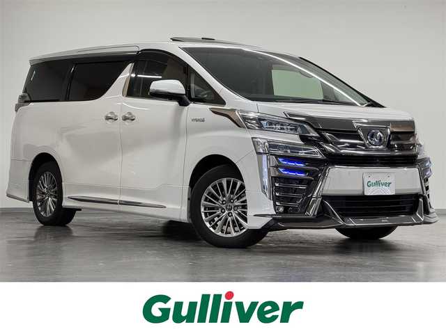 トヨタ ヴェルファイア ハイブリット ZR Gエディション 三重県 2019(平31)年 7.7万km ホワイトパールクリスタルシャイン ハイブリッド/E-four（4WD）/MTモード付インパネCVT/純正 9型ナビ/（AM/FM/CD/DVD/Blu-ray/SDREC/SD/USB/Bluetooth/VTR/AUX/TV）/12.1型 後席モニター/パノラミックビューモニター（シースルービュー機能付）/【OP】JBLプレミアムサウンド/両側パワースライドドア/モデリスタエアロ（F/S/R下）/ドライブレコーダー 前方/ビルトイン ETC2.0/Toyota Safety Sense/・プリクラッシュセーフティ/・レーントレーシングアシスト/・クリアランスソナー/・パーキングサポートブレーキ/・【OP】ブラインドスポットモニター&リヤクロストラフィックアラート&PKSB（後方接近車両）/・ロードサインアシスト/・レーダークルーズ/・先行車発進告知機能/装備/【MOP】/　・ツインムーンルーフ/　・3眼LEDヘッドランプ&アダプティブハイビーム［AHS］/　・ITS Connect/　・デジタルインナーミラー/・本革シート/・パワーバックドア/・シートヒーター（D/N/2nd）&ベンチレーション（D/N）/・パワーシート（D8way/N4way）/・エグゼクティブパワーシート（2nd電動リクライニング&オットマン）/・予備キーx1、エンジンスターター