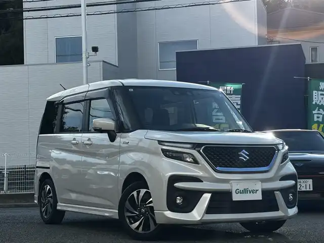 スズキ ソリオ バンディット HV MV 熊本県 2023(令5)年 2.4万km ピュアホワイトP 純正9インチナビ（3A103-59S06）/【フルセグTV/CD/DVD】/全方位カメラ/バックカメラ/両側パワースライドドア/レーダークルーズコントロール/衝突被害軽減ブレーキ/レーンキープアシスト/ヘッドアップディスプレイ/アイドリングストップ/シートヒーター/純正15インチAW/前後ドライブレコーダー/ビルトインETC/オートLEDヘッドライト/ウィンカーミラー/プッシュスタート/ステアリングスイッチ/純正フロアマット/純正ドアバイザー/横滑り防止/盗難防止装置/保証書/取扱説明書