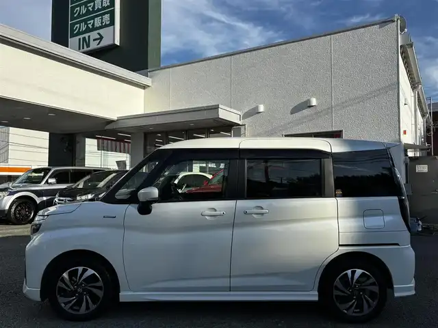 スズキ ソリオ バンディット HV MV 熊本県 2023(令5)年 2.4万km ピュアホワイトP 純正9インチナビ（3A103-59S06）/【フルセグTV/CD/DVD】/全方位カメラ/バックカメラ/両側パワースライドドア/レーダークルーズコントロール/衝突被害軽減ブレーキ/レーンキープアシスト/ヘッドアップディスプレイ/アイドリングストップ/シートヒーター/純正15インチAW/前後ドライブレコーダー/ビルトインETC/オートLEDヘッドライト/ウィンカーミラー/プッシュスタート/ステアリングスイッチ/純正フロアマット/純正ドアバイザー/横滑り防止/盗難防止装置/保証書/取扱説明書