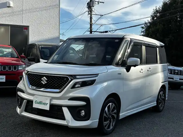 スズキ ソリオ バンディット HV MV 熊本県 2023(令5)年 2.4万km ピュアホワイトP 純正9インチナビ（3A103-59S06）/【フルセグTV/CD/DVD】/全方位カメラ/バックカメラ/両側パワースライドドア/レーダークルーズコントロール/衝突被害軽減ブレーキ/レーンキープアシスト/ヘッドアップディスプレイ/アイドリングストップ/シートヒーター/純正15インチAW/前後ドライブレコーダー/ビルトインETC/オートLEDヘッドライト/ウィンカーミラー/プッシュスタート/ステアリングスイッチ/純正フロアマット/純正ドアバイザー/横滑り防止/盗難防止装置/保証書/取扱説明書