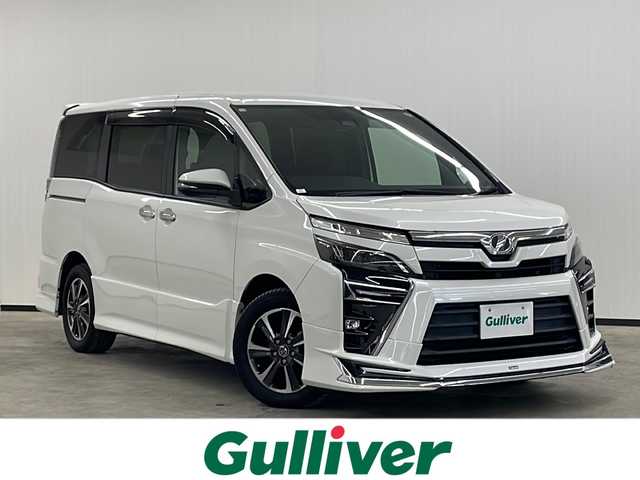 トヨタ ヴォクシー ZS 煌 長崎県 2018(平30)年 9万km ホワイトパールクリスタルシャイン モデリスタフルエアロ　/純正１２．１型後席モニター/純正１０型ナビ/・フルセグＴＶ/・DVD/・Bluetooth/・バックカメラ/セーフティセンス/・先行車発信告知/・レーンディパーチャーアラート/・オートハイビーム/両側電動スライドドア/ビルトインETC/クルーズコントロール/LEDヘッドライト/オートリトラミラー/黒革ハンドル/ステアリングリモコン/リアサンシェード/シートバックテーブル/純正バイザー