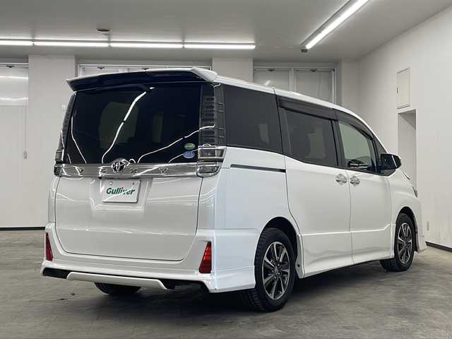 トヨタ ヴォクシー ZS 煌 長崎県 2018(平30)年 9万km ホワイトパールクリスタルシャイン モデリスタフルエアロ　/純正１２．１型後席モニター/純正１０型ナビ/・フルセグＴＶ/・DVD/・Bluetooth/・バックカメラ/セーフティセンス/・先行車発信告知/・レーンディパーチャーアラート/・オートハイビーム/両側電動スライドドア/ビルトインETC/クルーズコントロール/LEDヘッドライト/オートリトラミラー/黒革ハンドル/ステアリングリモコン/リアサンシェード/シートバックテーブル/純正バイザー