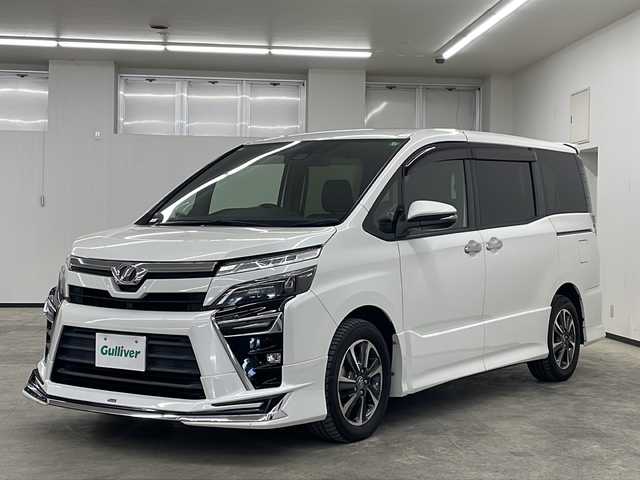 トヨタ ヴォクシー ZS 煌 長崎県 2018(平30)年 9万km ホワイトパールクリスタルシャイン モデリスタフルエアロ　/純正１２．１型後席モニター/純正１０型ナビ/・フルセグＴＶ/・DVD/・Bluetooth/・バックカメラ/セーフティセンス/・先行車発信告知/・レーンディパーチャーアラート/・オートハイビーム/両側電動スライドドア/ビルトインETC/クルーズコントロール/LEDヘッドライト/オートリトラミラー/黒革ハンドル/ステアリングリモコン/リアサンシェード/シートバックテーブル/純正バイザー