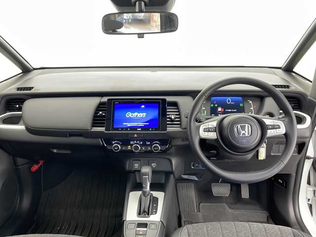 ホンダ フィット e:HEVホーム 長野県 2024(令6)年 0.9万km プラチナホワイトパール 純正ディスプレイオーディオ/（Bluetooth／USB／FM／AM)/バックカメラ/ETC/Honda SENSING/・クルースコントロール（追従あり）/・路線逸脱抑制機能/・踏み間違い衝突軽減システム/・衝突軽減ブレーキ/クリアランスソナー/電動パーキングブレーキ/ブレーキホールド/LEDヘッドライト/オートマチックハイビーム/オートライト/ハーフレザーシート/純正ホイールキャップ/ドアバイザー/純正フロアマット/スマートキー/スペアキー１本