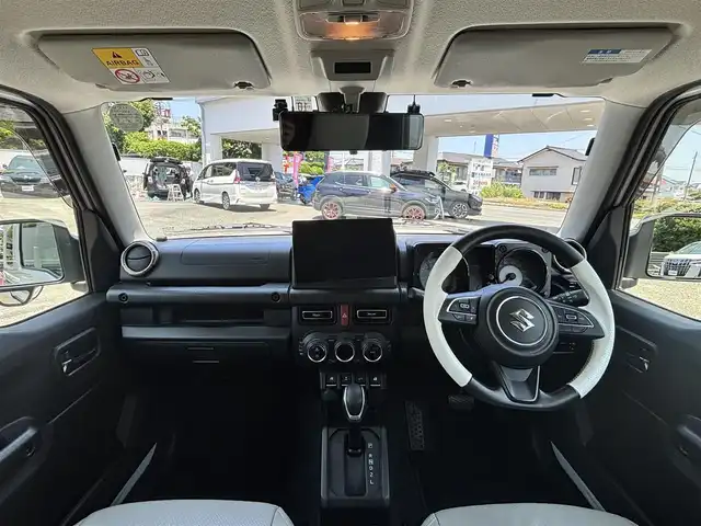 スズキ ジムニー シエラ JC 熊本県 2022(令4)年 2.4万km ピュアホワイトP ワンオーナー/ダムドリトルGスタンダードコンプリートカー/・フロントグリル/・フロントバンパー/・オーバーフェンダー＆アルミステップサイドモール/・スペアタイヤハードカバー/・G15エンブレム/社外ナビ（CN-F1X10BHD）/【10V型有機ELディスプレイ/フルセグTV/BT】/バックカメラ/社外デジタルインナーミラー/デュアルセンサーブレーキサポート/車線逸脱警報システム/クルーズコントロール/社外ダウンサス/社外18インチアルミホイール（純正品積込有）/革巻きツートンステアリング（純正品積込有）/ビルトインETC/ドライブレコーダー（前後）/LEDオートライト/レザー調シートカバー/シートヒーター/プッシュスタート/スマートキー/保証書/取扱説明書