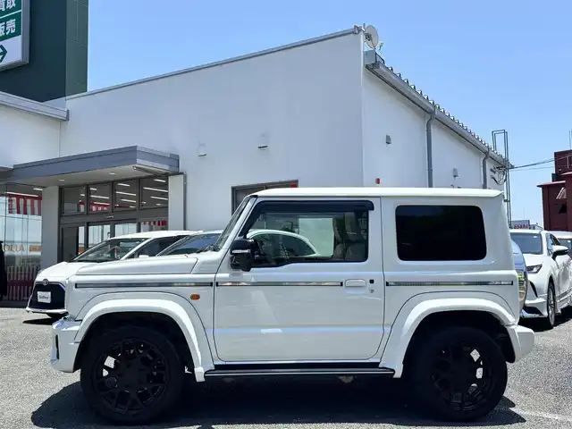 スズキ ジムニー シエラ JC 熊本県 2022(令4)年 2.4万km ピュアホワイトP ワンオーナー/ダムドリトルGスタンダードコンプリートカー/・フロントグリル/・フロントバンパー/・オーバーフェンダー＆アルミステップサイドモール/・スペアタイヤハードカバー/・G15エンブレム/社外ナビ（CN-F1X10BHD）/【10V型有機ELディスプレイ/フルセグTV/BT】/バックカメラ/社外デジタルインナーミラー/デュアルセンサーブレーキサポート/車線逸脱警報システム/クルーズコントロール/社外ダウンサス/社外18インチアルミホイール（純正品積込有）/革巻きツートンステアリング（純正品積込有）/ビルトインETC/ドライブレコーダー（前後）/LEDオートライト/レザー調シートカバー/シートヒーター/プッシュスタート/スマートキー/保証書/取扱説明書