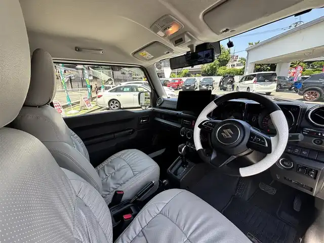 スズキ ジムニー シエラ JC 熊本県 2022(令4)年 2.4万km ピュアホワイトP ワンオーナー/ダムドリトルGスタンダードコンプリートカー/・フロントグリル/・フロントバンパー/・オーバーフェンダー＆アルミステップサイドモール/・スペアタイヤハードカバー/・G15エンブレム/社外ナビ（CN-F1X10BHD）/【10V型有機ELディスプレイ/フルセグTV/BT】/バックカメラ/社外デジタルインナーミラー/デュアルセンサーブレーキサポート/車線逸脱警報システム/クルーズコントロール/社外ダウンサス/社外18インチアルミホイール（純正品積込有）/革巻きツートンステアリング（純正品積込有）/ビルトインETC/ドライブレコーダー（前後）/LEDオートライト/レザー調シートカバー/シートヒーター/プッシュスタート/スマートキー/保証書/取扱説明書