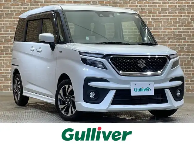 スズキ ソリオ バンディット HV MV 岩手県 2023(令5)年 7.4万km ピュアホワイトP ４WD/カラーヘッドアップディスプレイ/左側パワースライドドア/スズキセーフティサポート/デュアルカメラブレーキサポート/アダプティブクルーズコントロール/車線逸脱警報/誤発進抑制機能/標識認識機能/先行車発進お知らせ機能/リヤパーキングセンサー/横滑り防止装置/アイドリングストップ/スリムサーキュレーター/シートヒーター/ロールサンシェード/LEDヘッドライト/純正15インチアルミホイール