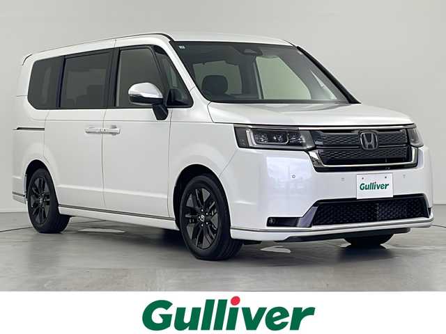 ホンダ ステップワゴン スパーダ eHEV 岐阜県 2025(令7)年 0.1千km プラチナホワイトパール 登録済み未使用車/純正11.4インチナビゲーション【LXM-247VFLi】/AppleCarplay /Android Auto/Bluetooth /CD DVD/フルセグテレビ/AM FM/SD/USB/革巻きステアリング/ステアリングリモコン/パドルシフト/メモリー機能付きパワーバックドア/ハーフレザーシート/シートヒーター(D/N席)/ ２列目シートオットマン/全列USBチャージャー付/両側パワースライドドア/LEDヘッドライト/ヘッドライトレベライザー/オートハイビーム/アダプティブドライビングビーム/スマートキー/プッシュスタート/スペアキー有/ホンダセンシング/先行車発進お知らせ機能/歩行者事故低減ステアリング/路外逸脱抑制機能/標識認識機能/渋滞追従機能付アダプティブクルーズコントロール（ACC）/車線維持支援システム（LKAS）/トラフィックジャムアシスト（渋滞運転支援機能）/ブラインドスポットインフォメーション/誤発進抑制機能/後方誤発進抑制機能/近距離衝突軽減ブレーキ/アクセル抑制機能/パーキングセンサーシステム/後退出庫サポート/減速セレクター