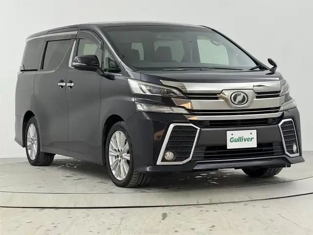 トヨタ ヴェルファイア Z Aエディション 熊本県 2015(平27)年 6.3万km スパークリングブラックパールクリスタルシャイン 純正9インチナビ（NSZT-Y６４T)/バックカメラ/フルセグTV/BT/CD/DVD/衝突軽減ブレーキ/レーダークルコン/オートライト/前後コーナーセンサー/純正フリップダウンモニター/両側パワスラ/ビルトインETC/オットマン/LEＤヘッドライト/フォグランプ/１００V充電/純正18インチアルミ/純正フロアマット/プッシュスタート