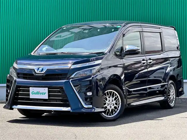トヨタ ヴォクシー ハイブリッド ZS 煌Ⅱ 宮城県 2019(令1)年 2.5万km ブラッキッシュアゲハガラスフレーク セーフティセンス/・プリクラッシュセーフティ/・レーンディパーチャーアラート/・オートマチックハイビーム/・先行車発進告知機能/インテリジェントクリアランスソナー/純正12インチフリップダウンモニター（V12T-R68C）/純正10インチナビ（NSZN-Z68T）/・CD/DVD/・Bluetooth/・フルセグTV/バックカメラ/ビルトインETC/ドライブレコーダー/GPSレーダー探知機/両側パワースライドドア/前席シートヒーター/革巻きステアリング/クルーズコントロール/ステアリングスイッチ/LEDヘッドランプ/フォグランプ/オートライト/スマートキー＆プッシュスタート/スペアキー1本/電動格納ミラー/純正16インチAW/純正フロアマット/純正ドアバイザー/Wエアバッグ