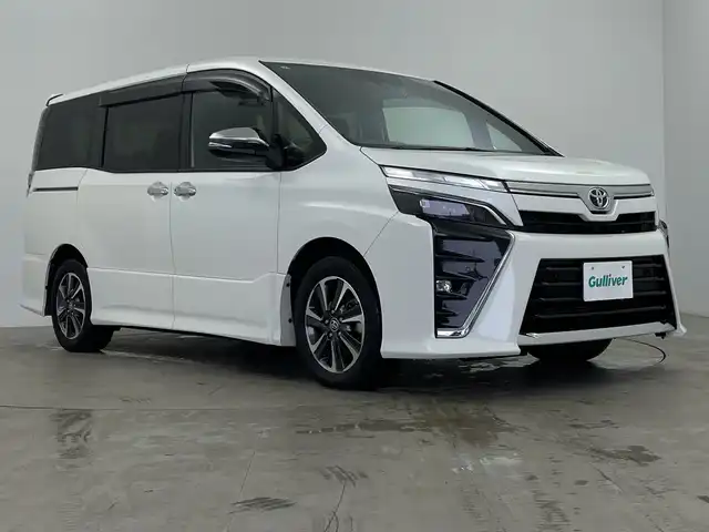 トヨタ ヴォクシー ZS 煌Ⅲ 鹿児島県 2021(令3)年 2.7万km ホワイトパールクリスタルシャイン 登録時走行距離 27085km/純正９型ナビ　/フルセグＴＶ　/12.1インチフリップダウンモニター　(V12T-R68C)/バックカメラ　/前後ドライブレコーダー/純正１６インチアルミホイール　/両側パワースライドドア/ビルトインＥＴＣ　/クルーズコントロール　/ＬＥＤヘッドライト　/フォグランプ/オートマチックハイビーム　/オートライト/ハーフレザーシート/純正フロアマット/前後コーナーセンサー/衝突軽減システム/盗難防止装置/横滑り防止装置/レーンキープアシスト/アイドリングストップ