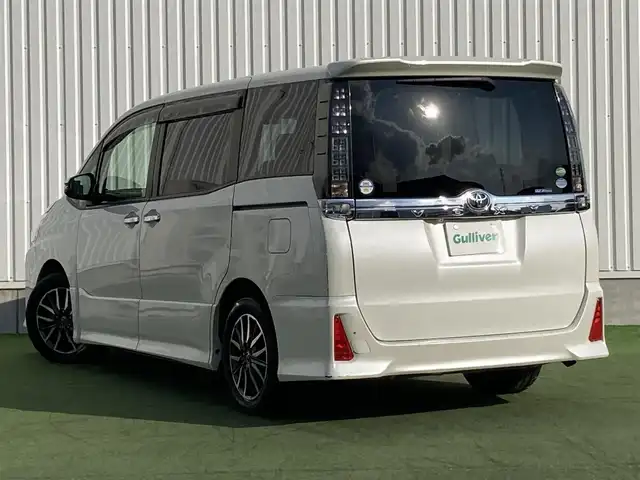 トヨタ ヴォクシー ZS 煌 香川県 2015(平27)年 12万km ホワイトパールクリスタルシャイン 登録時走行距離：119662km/アルパイン9型SDナビ/　CD DVD BT フルセグTV/バックカメラ/アルパイン10.1型フリップダウンモニター/両側パワースライドドア/LEDヘッドライト/オートライト/フォグランプ/MTモード付AT/ビルトインETC/ドライブレコーダー/ロールサンシェード/ISOFIX/ウォークスルー/革巻きステアリング/ステアリングスイッチ/プッシュスタート/スマートキー/スペアキー