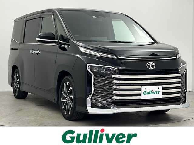 トヨタ ヴォクシー S－Z 大阪府 2022(令4)年 3.2万km アティチュードブラックマイカ 純正10.5インチディスプレイオーディオ(ナビ有)/【フルセグTV/Bluetooth/HDMI/CD/DVD】/純正14インチ後席モニター/快適利便パッケージ/パワーバックドア/後席オットマン/ハンズフリーデュアルパワースライドドア/ステアリングヒーター/nanoe/両側パワースライドドア/トヨタセーフティセンス/プリクラッシュセーフティ/パーキングサポートブレーキ/レーダークルーズコントロール/レーンキープアシスト/オートマチックハイビーム/前後コーナーセンサー/バックカメラ/ハーフレザーシート/前後シートヒーター/ステアリングヒーター/LEDヘッドライト/スマートキー