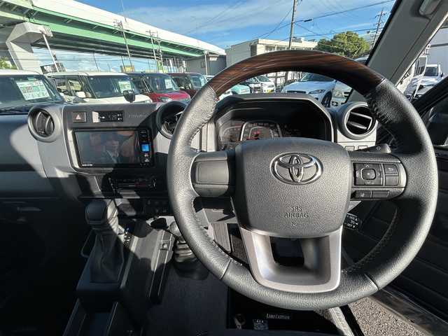 トヨタ ランドクルーザー AX 愛知県 2025(令7)年 0.1万km アティチュードブラックマイカ ４ＷＤ/純正シート（ハーフレザー）/純正ＳＤナビ（NMZK-W73D）/バックカメラ/衝突軽減ブレーキ/オートハイビームシステム/レーンディパーチャーアラート/クルーズコントロール/ＢＴ/ＤＴＶ/ＣＤ／ＤＶＤ/ＥＴＣ/デフロック（標準）/ＤＡＣ/自動防眩ミラー（バックカメラ機能付き）/丸目ＬＥＤヘッドライト/背面スペアタイヤ（カバー付き）/純正フロアマット/純正ＡＷ１６インチ/リアガラス熱線