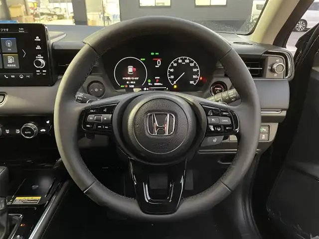ホンダ ヴェゼル ハイブリッド e:HEV Z 滋賀県 2025(令7)年 0.1千km クリスタルブラックパール 純正9インチナビ/【Bluetooth/USB/Apple CarPlay/Android Auto】/バックカメラ/ハーフレザーシート/ホンダセンシング/・衝突軽減ブレーキ（CMBS）/・先行車発進お知らせ機能/・歩行者事故低減ステアリング/・路外逸脱抑制機能/・標識認識機能/・渋滞追従機能付アダプティブクルーズコントロール/・車線維持支援システム（LKAS）/・トラフィックジャムアシスト（渋滞運転支援機能）/・ブラインドスポットインフォメーション/・誤発進抑制機能/・後方誤発進抑制機能/・近距離衝突軽減ブレーキ/・急アクセル抑制機能/・パーキングセンサーシステム/・後退出庫サポート/・オートハイビーム/・アダプティブドライビングビーム/LEDヘッドライト/クリアランスソナー/シートヒーター/ステアリングヒーター/ヒルディセントコントロール/ワイヤレス充電/ビルトインETC2.0/衝突軽減ブレーキ/パワーバックドア/電動パーキングブレーキ/オートブレーキホールド/純正フロアマット