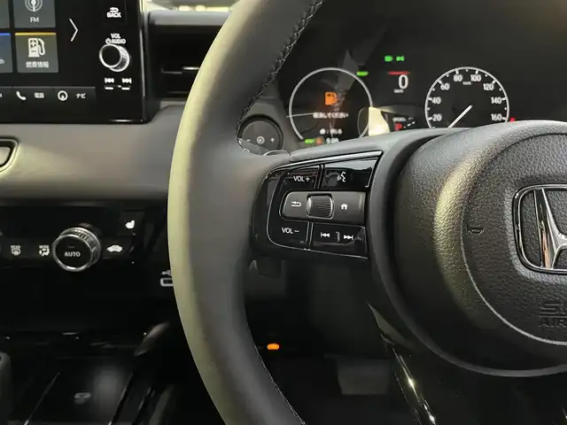 ホンダ ヴェゼル ハイブリッド e:HEV Z 滋賀県 2025(令7)年 0.1千km クリスタルブラックパール 純正9インチナビ/【Bluetooth/USB/Apple CarPlay/Android Auto】/バックカメラ/ハーフレザーシート/ホンダセンシング/・衝突軽減ブレーキ（CMBS）/・先行車発進お知らせ機能/・歩行者事故低減ステアリング/・路外逸脱抑制機能/・標識認識機能/・渋滞追従機能付アダプティブクルーズコントロール/・車線維持支援システム（LKAS）/・トラフィックジャムアシスト（渋滞運転支援機能）/・ブラインドスポットインフォメーション/・誤発進抑制機能/・後方誤発進抑制機能/・近距離衝突軽減ブレーキ/・急アクセル抑制機能/・パーキングセンサーシステム/・後退出庫サポート/・オートハイビーム/・アダプティブドライビングビーム/LEDヘッドライト/クリアランスソナー/シートヒーター/ステアリングヒーター/ヒルディセントコントロール/ワイヤレス充電/ビルトインETC2.0/衝突軽減ブレーキ/パワーバックドア/電動パーキングブレーキ/オートブレーキホールド/純正フロアマット