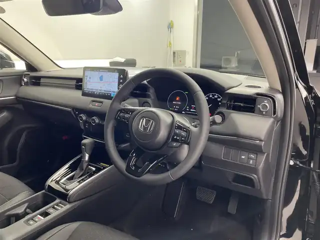 ホンダ ヴェゼル ハイブリッド e:HEV Z 滋賀県 2025(令7)年 0.1千km クリスタルブラックパール 純正9インチナビ/【Bluetooth/USB/Apple CarPlay/Android Auto】/バックカメラ/ハーフレザーシート/ホンダセンシング/・衝突軽減ブレーキ（CMBS）/・先行車発進お知らせ機能/・歩行者事故低減ステアリング/・路外逸脱抑制機能/・標識認識機能/・渋滞追従機能付アダプティブクルーズコントロール/・車線維持支援システム（LKAS）/・トラフィックジャムアシスト（渋滞運転支援機能）/・ブラインドスポットインフォメーション/・誤発進抑制機能/・後方誤発進抑制機能/・近距離衝突軽減ブレーキ/・急アクセル抑制機能/・パーキングセンサーシステム/・後退出庫サポート/・オートハイビーム/・アダプティブドライビングビーム/LEDヘッドライト/クリアランスソナー/シートヒーター/ステアリングヒーター/ヒルディセントコントロール/ワイヤレス充電/ビルトインETC2.0/衝突軽減ブレーキ/パワーバックドア/電動パーキングブレーキ/オートブレーキホールド/純正フロアマット