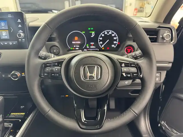 ホンダ ヴェゼル ハイブリッド e:HEV Z 滋賀県 2025(令7)年 0.1千km クリスタルブラックパール 純正9インチナビ/【Bluetooth/USB/Apple CarPlay/Android Auto】/バックカメラ/ハーフレザーシート/ホンダセンシング/・衝突軽減ブレーキ（CMBS）/・先行車発進お知らせ機能/・歩行者事故低減ステアリング/・路外逸脱抑制機能/・標識認識機能/・渋滞追従機能付アダプティブクルーズコントロール/・車線維持支援システム（LKAS）/・トラフィックジャムアシスト（渋滞運転支援機能）/・ブラインドスポットインフォメーション/・誤発進抑制機能/・後方誤発進抑制機能/・近距離衝突軽減ブレーキ/・急アクセル抑制機能/・パーキングセンサーシステム/・後退出庫サポート/・オートハイビーム/・アダプティブドライビングビーム/LEDヘッドライト/クリアランスソナー/シートヒーター/ステアリングヒーター/ヒルディセントコントロール/ワイヤレス充電/ビルトインETC2.0/衝突軽減ブレーキ/パワーバックドア/電動パーキングブレーキ/オートブレーキホールド/純正フロアマット
