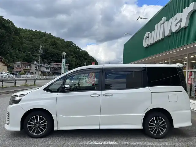 トヨタ ヴォクシー ZS 煌Ⅱ 岐阜県 2016(平28)年 9万km ホワイトパールクリスタルシャイン 4WD/SDナビ（Panasonic　CN-S310D）/【TV．Bluetooth．CD.DVD.AM/FM】/後席用モニター/バックカメラ/スマートキー/プッシュスタート/両側パワースライドドア/レーンキープアシスト/衝突軽減ブレーキ/ETC/ドライブレコーダー/ウィンカーミラー/オートライト/オートマチックハイビーム/フォグライト/積み込みスタッドレスタイヤ/ドアバイザー/保証書/取扱説明書/スペアキー