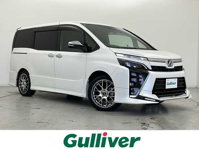 トヨタ ヴォクシー ZS 宮城県 2019(令1)年 6.1万km ホワイトパールクリスタルシャイン 禁煙車/TRDエアロパーツ（F/R）/フリップダウンモニター/トヨタセーフティセンス/・プリクラッシュセーフティ/・レーンディパーチャーアラート/・オートマチックハイビーム/・レーダークルーズコントロール/バックカメラ/両側パワースライドドア/社外9インチナビ/・BT/SD/CD/DVD/AM/FM/フルセグTV/ドライブレコーダー（F/R）/ETC/革巻きステアリング/ステアリングスイッチ/プッシュスタート/スマートキー/LEDヘッドライト/LEDフォグランプ/サンシェード/シートバックテーブル/純正ドアバイザー/純正フロアマット/社外18インチアルミホイール/横滑り防止装置/アイドリングストップ