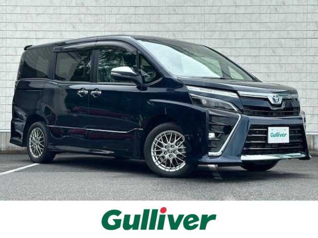 トヨタ ヴォクシー ハイブリッド ZS 煌Ⅲ 大阪府 2020(令2)年 0.7万km ブラッキッシュアゲハガラスフレーク 純正9型ナビ(BT/CD/DVD/フルセグ)/バックカメラ/衝突被害軽減システム/レーンキープアシスト/コーナーセンサー/横滑り防止装置/盗難防止装置/クルーズコントロール/純正フロアマット/純正アルミホイール/シートヒーター/ハーフレザー/ウォークスルー/純正前後ドライブレコーダー/ビルトインETC/両側パワースライドドア/スマートキー×2/LEDヘッドライト