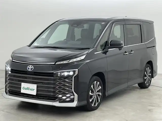 トヨタ ヴォクシー ハイブリッド S－Z 福岡県 2023(令5)年 1.4万km グリッターブラックガラスフレーク ワンオーナー　/後席モニター　/純正１０．５型ＤＡナビ　/バックカメラ　/ＥＴＣ２．０　/ＡＣＣ　/コーナーセンサー　/快適利便パッケージ　/衝突被害軽減ブレーキ　/レーンキープ　/両側電動スライドドア　/シートヒーター/パワーリアゲート