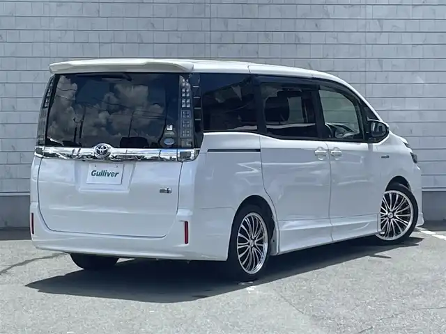 トヨタ ヴォクシー ハイブリッド V 愛知県 2014(平26)年 6万km ホワイトパールクリスタルシャイン ローダウンスプリング/純正9型ナビ/　(Bluetooth/CD/DVD)/フルセグTV/両側パワースライドドア/バックモニター/ビルトインETC/純正11型後席ディスプレイ/クルーズコントロール/S-VSC/LEDヘッドランプ/オートライト/デュアルオートエアコン/本革巻きステアリング/ステアリングスイッチ/前席快適温熱シート/2列目キャプテンシート/2列目サイドテーブル/ロクサーニEX18インチアルミホイール/スマートエントリー/プッシュスタートシステム/禁煙車