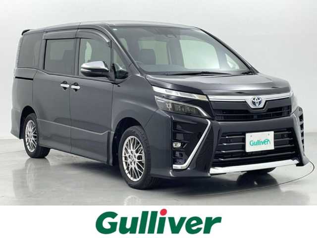 トヨタ ヴォクシー ハイブリッド ZS 煌Ⅲ 熊本県 2020(令2)年 6.6万km ブラック 純正10型ナビNSZT-Z68T(CD・DVD・フルセグ・BT・SD）/バックカメラ/純正フリップダウンモニター/ビルトインETC/トヨタセーフティーセンス/・駐車時支援パーキングサポートシステム/・衝突被害軽減ブレーキ/・車線逸脱抑制装置/・先行車発進お知らせ機能/・前後クリアランスソナー/クルーズコントロール/両側電動スライドドア/ハーフレザーシート/前席シートヒーター/リアオートエアコン/純正フロアマット/純正16インチAW/オートライト/LEDヘッドライト/オートマチックハイビーム/フォグランプ/スマートキー/プッシュスタート