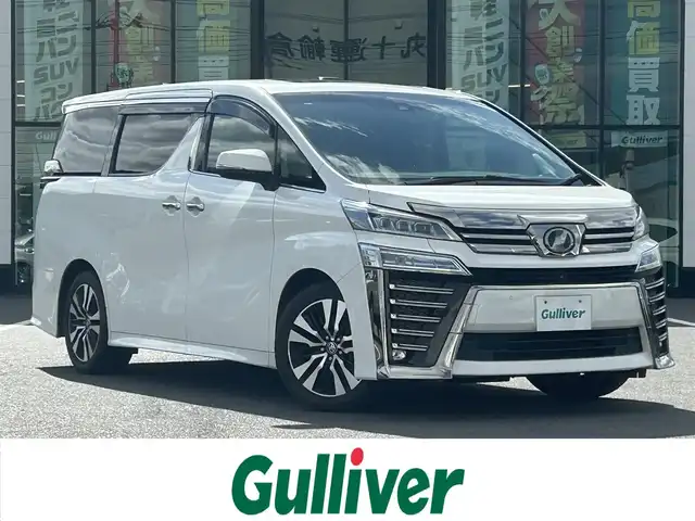トヨタ ヴェルファイア Z Gエディション 岡山県 2019(令1)年 9.3万km ホワイトパールクリスタルシャイン 登録時走行距離92/577km/純正メーカーオプション10インチナビ/（AM/FM/DISC/TV/Bluetooth）/純正12.1型フリップダウンモニター/ツインムーンルーフ/JBLプレミアムサウンド/トヨタセーフティセンス/・プリクラッシュセーフティ/・レーンディパーチャーアラート/・アダプティブハイビーム/・レーダークルーズコントロール/パノラミックビューモニター/パーキングアシスト/3眼LEDヘッドランプ/デジタルインナーミラー/ブラインドスポットモニター/両側パワースライドドア/スペアキー×1/パワーバックドア/パワーシート(全席)/シートヒーター(全席)/シートベンチレーション(全席)/ステアリングヒーター/ビルトインETC2.0/前後ドライブレコーダー/電動パーキングブレーキ/オートブレーキホールド/プッシュスタート/スマートキー