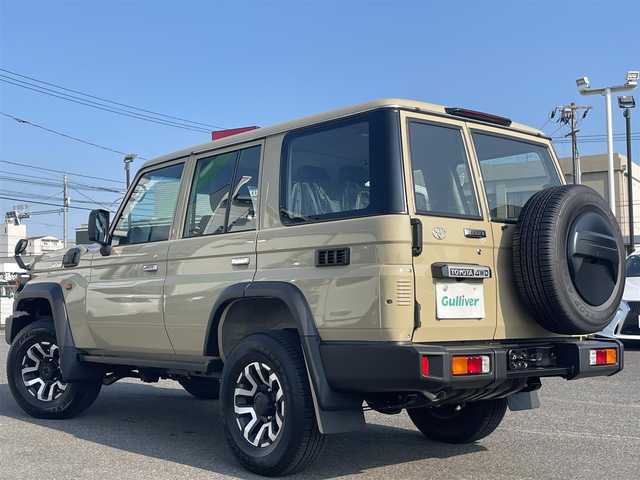 トヨタ ランドクルーザー AX 広島県 2025(令7)年 0.1万km未満 ベージュ 登録時走行距離 5km/登録年月日　令和7年6月30日/ワンオーナー/禁煙車/ディーゼルターボ/4WD/バックカメラ内臓自動防眩式ルームミラー/クルーズコントロール/衝突被害軽減システム（PCS）/車線逸脱警報（LDA）/標識認識機能（RSA）/ハーフレザーシート/後席シートヒーター/木目調革巻きステアリング/純正丸目LEDヘッドライト/LEDフォグライト/オートライト/オートマチックハイビーム/ヘッドライトレベライザー/スマートキー×2/メカニカルキー×3/MTモード付きAT/フェンダーミラー/純正アルミホイール 16インチ/横滑防止装置/盗難防止装置/取扱説明書/新車時整備手帳（保証書）