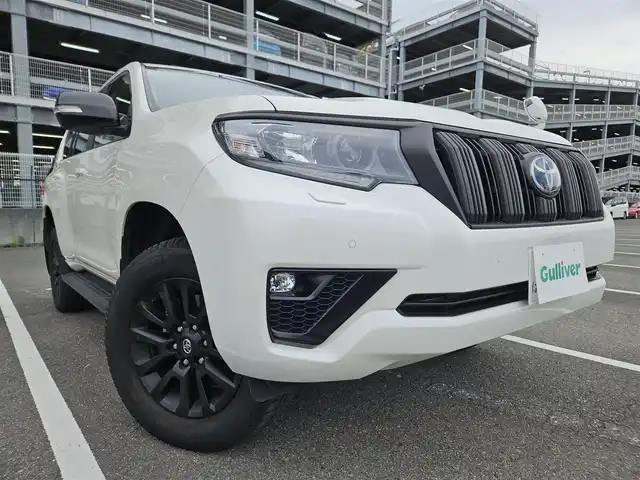 トヨタ ランドクルーザー プラド TX Lパッケージ マットブラED 兵庫県 2023(令5)年 2万km ホワイトパールクリスタルシャイン 4WD/純正ナビ/フルセグTV/バックカメラ/ビルトインETC2.0/ドライブレコーダー/アルパイン後席用フリップダウンモニター/レーダークルーズコントロール/クリアランスソナー/セーフティセンス/・衝突被害軽減ブレーキ/・車線逸脱防止支援/・オートマチックハイビーム/・標識認識/パーキングサポートブレーキ/LEDヘッドランプ/革巻きステアリング/ベージュ革シート/前席パワーシート/前席シートヒーター/ベンチレーション/3列目電動格納シート/純正18インチアルミホイール/スマートキー/プッシュエンジンスタート/禁煙車