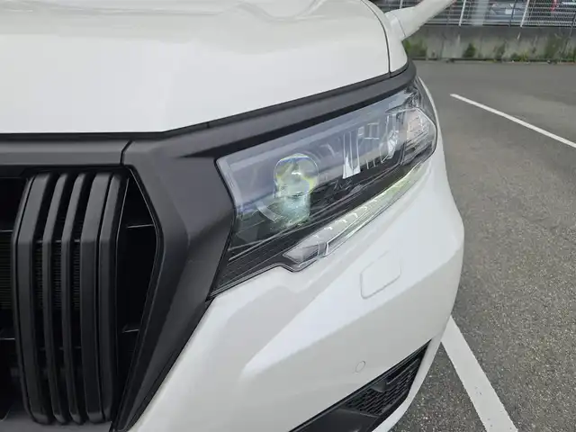 トヨタ ランドクルーザー プラド TX Lパッケージ マットブラED 兵庫県 2023(令5)年 2万km ホワイトパールクリスタルシャイン 4WD/純正ナビ/フルセグTV/バックカメラ/ビルトインETC2.0/ドライブレコーダー/アルパイン後席用フリップダウンモニター/レーダークルーズコントロール/クリアランスソナー/セーフティセンス/・衝突被害軽減ブレーキ/・車線逸脱防止支援/・オートマチックハイビーム/・標識認識/パーキングサポートブレーキ/LEDヘッドランプ/革巻きステアリング/ベージュ革シート/前席パワーシート/前席シートヒーター/ベンチレーション/3列目電動格納シート/純正18インチアルミホイール/スマートキー/プッシュエンジンスタート/禁煙車