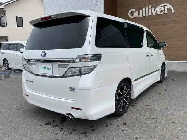 トヨタ ヴェルファイア ハイブリット ZR Gエディション 道央・札幌 2013(平25)年 9.4万km ホワイトパールクリスタルシャイン 登録時走行距離 93155km/　4　W　D　/フロントモデリスタエアロ/ローダウン/純正メーカーOPナビ/(AM/FM/CD/DVD/BT)/フルセグTV/バックカメラ/プレミアムサウンド/純正フリップダウンモニター/両側パワースライドドア/パワーバックドア/ビルトインETC/黒革シート/助手席オットマン/2列目キャプテンシート/社外ウィンカーミラー/社外フロントグリル/ウッドコンビステアリング/社外レーダー/純正サスペンション積込/社外テール積込(動作未確認)/純正AW付冬タイヤ積込/215/65R16 2023年製 7mm