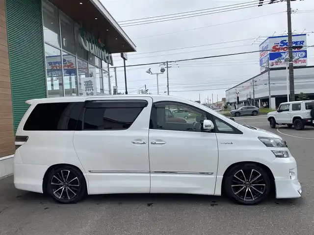 トヨタ ヴェルファイア ハイブリット ZR Gエディション 道央・札幌 2013(平25)年 9.4万km ホワイトパールクリスタルシャイン 登録時走行距離 93155km/　4　W　D　/フロントモデリスタエアロ/ローダウン/純正メーカーOPナビ/(AM/FM/CD/DVD/BT)/フルセグTV/バックカメラ/プレミアムサウンド/純正フリップダウンモニター/両側パワースライドドア/パワーバックドア/ビルトインETC/黒革シート/助手席オットマン/2列目キャプテンシート/社外ウィンカーミラー/社外フロントグリル/ウッドコンビステアリング/社外レーダー/純正サスペンション積込/社外テール積込(動作未確認)/純正AW付冬タイヤ積込/215/65R16 2023年製 7mm