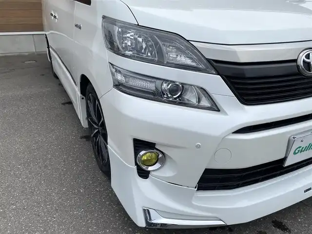 トヨタ ヴェルファイア ハイブリット ZR Gエディション 道央・札幌 2013(平25)年 9.4万km ホワイトパールクリスタルシャイン 登録時走行距離 93155km/　4　W　D　/フロントモデリスタエアロ/ローダウン/純正メーカーOPナビ/(AM/FM/CD/DVD/BT)/フルセグTV/バックカメラ/プレミアムサウンド/純正フリップダウンモニター/両側パワースライドドア/パワーバックドア/ビルトインETC/黒革シート/助手席オットマン/2列目キャプテンシート/社外ウィンカーミラー/社外フロントグリル/ウッドコンビステアリング/社外レーダー/純正サスペンション積込/社外テール積込(動作未確認)/純正AW付冬タイヤ積込/215/65R16 2023年製 7mm
