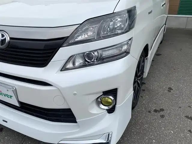 トヨタ ヴェルファイア ハイブリット ZR Gエディション 道央・札幌 2013(平25)年 9.4万km ホワイトパールクリスタルシャイン 登録時走行距離 93155km/　4　W　D　/フロントモデリスタエアロ/ローダウン/純正メーカーOPナビ/(AM/FM/CD/DVD/BT)/フルセグTV/バックカメラ/プレミアムサウンド/純正フリップダウンモニター/両側パワースライドドア/パワーバックドア/ビルトインETC/黒革シート/助手席オットマン/2列目キャプテンシート/社外ウィンカーミラー/社外フロントグリル/ウッドコンビステアリング/社外レーダー/純正サスペンション積込/社外テール積込(動作未確認)/純正AW付冬タイヤ積込/215/65R16 2023年製 7mm