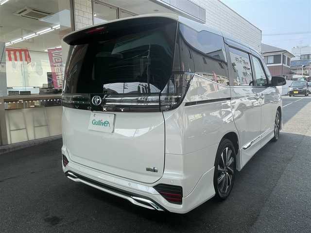 トヨタ ヴォクシー ハイブリッド S－Z 愛知県 2023(令5)年 1万km ホワイトパールクリスタルシャイン モデリスタエアロ/・フロント／サイド／リアアンダー/快適利便パッケージHifh/・ハンズフリー両側パワースライドドア/・ハンズフリーパワーバックドア/・2列目シートヒーター/・2列目オットマン/・ステアリングヒーター/・ナノイーX/ドライビングサポートパッケージ/・デジタルインナーミラー/・ヘッドアップディスプレイ/純正10.5型ディスプレイオーディオプラス/・車載メモリーナビ／DVD／Bluetooth／地デジTV/・Apple Car Play／Android Auto/・USB／HDMI/・ビルトインETC2.0/純正14型有機ELフリップダウンモニター/LEDヘッドライト＆クリアランスランプ/合皮＆ファブリックコンビシート/前席2列目シートヒーター/2列目充電用USBタイプC端子/ラゲッジルームアクセサリーコンセント/純正17インチAW/スマートキー