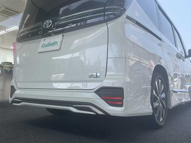 トヨタ ヴォクシー ハイブリッド S－Z 愛知県 2023(令5)年 1万km ホワイトパールクリスタルシャイン モデリスタエアロ/・フロント／サイド／リアアンダー/快適利便パッケージHifh/・ハンズフリー両側パワースライドドア/・ハンズフリーパワーバックドア/・2列目シートヒーター/・2列目オットマン/・ステアリングヒーター/・ナノイーX/ドライビングサポートパッケージ/・デジタルインナーミラー/・ヘッドアップディスプレイ/純正10.5型ディスプレイオーディオプラス/・車載メモリーナビ／DVD／Bluetooth／地デジTV/・Apple Car Play／Android Auto/・USB／HDMI/・ビルトインETC2.0/純正14型有機ELフリップダウンモニター/LEDヘッドライト＆クリアランスランプ/合皮＆ファブリックコンビシート/前席2列目シートヒーター/2列目充電用USBタイプC端子/ラゲッジルームアクセサリーコンセント/純正17インチAW/スマートキー
